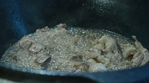 Close up view of meat being fried in a big cauldron. Cooking pilaf Stock Footage 170111592