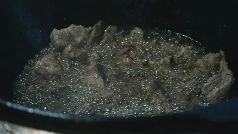 Close up view of meat being fried in a big cauldron. Cooking pilaf Stock Footage 170113074