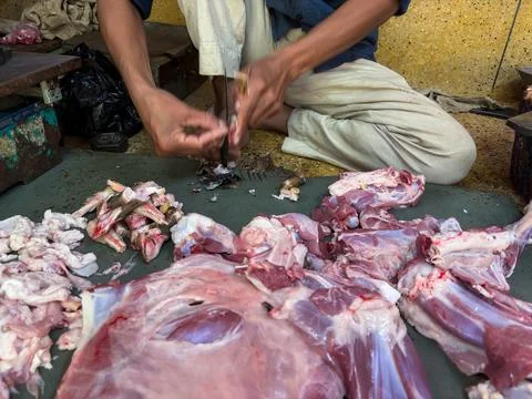Close view of meat vendor preparing fresh cuts using knife and cleaver 스톡 사진