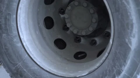 Close-up view of mechanic with pry bar installs a wheel on a truck rear axle Stock Footage 155285525