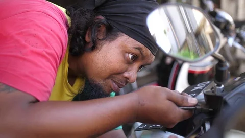 Close up view of mechanic using small pliers to loosen a nut so he can Stock Footage 111305696