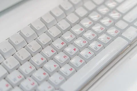 Close-up view of a mechanical keyboard with white keys and red lettering, pho Stock Photos