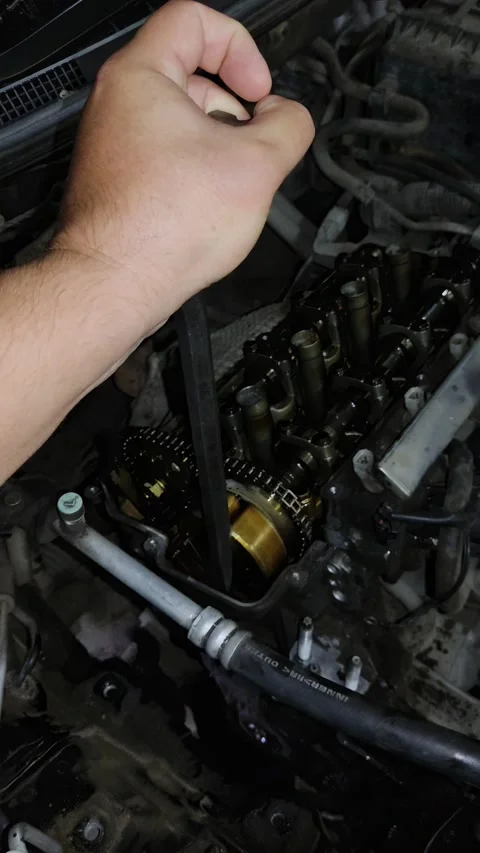 Close-Up View of Mechanic's Hand Adjusting Camshaft Components with Tool Stock Footage 346411266