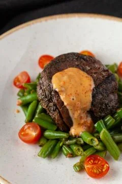 Close up view of a medium rare mignon steak, roasted with green beans and fre Stock-Fotos
