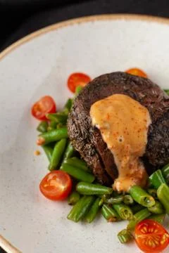 Close up view of a medium rare mignon steak, roasted with green beans and fre Stock-Fotos