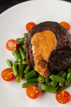 Close up view of a medium rare mignon steak, roasted with green beans and fre Stock-Fotos