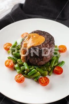 Close up view of a medium rare mignon steak, roasted with green beans and fre Stock Photos