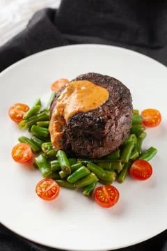 Close up view of a medium rare mignon steak, roasted with green beans and fre Stock-Fotos