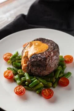 Close up view of a medium rare mignon steak, roasted with green beans and fre Stock-Fotos