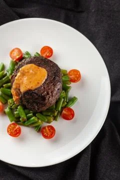 Close up view of a medium rare mignon steak, roasted with green beans and fre Stock-Fotos