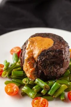 Close up view of a medium rare mignon steak, roasted with green beans and fre Stock-Fotos