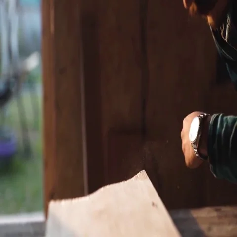 Close-up view of men working with electric jigsaw and wooden plank. sun flare on Stock Footage 69540437