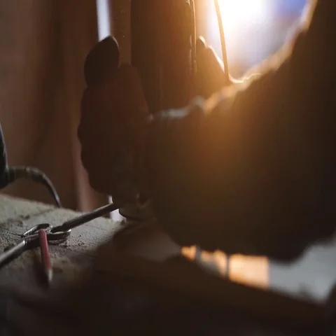 Close-up view of men working with electric jigsaw and wooden plank. sun flare on Stock Footage 69540998
