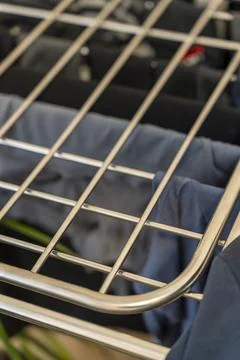A close-up view of a metal drying rack displaying various clothing items such as Stock Photos
