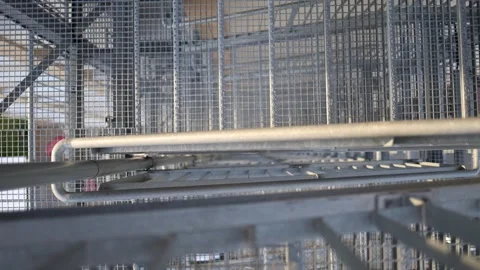 Close-up view of a metal fire escape staircase with geometric grid patterns. Saf Stock Footage 306008057