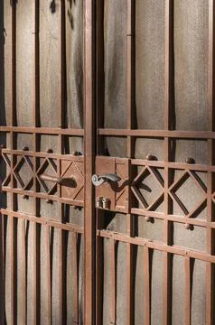A close-up view of a metal gate. The gate is made of reddish-brown metal with a Stock Photos