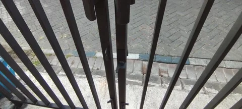 Close-up view of a metal gate with a hand opening it. Stock Footage 343556210
