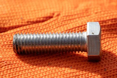 Close View of a Metallic Bolt on an Orange Fabric Surface During Daylight O.. Stock Photos