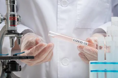 Close-up view of microbiologist in protective gloves holds biological tube of Stock Photos