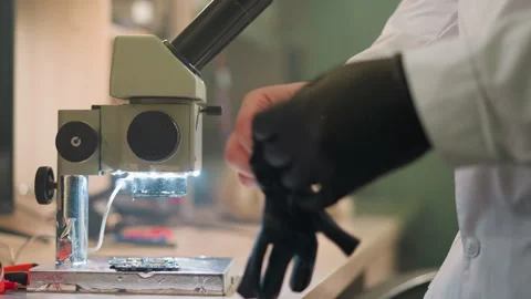 Close-Up View of Microscope and Circuit Board with Scientist Preparing for Stock Footage 282650051