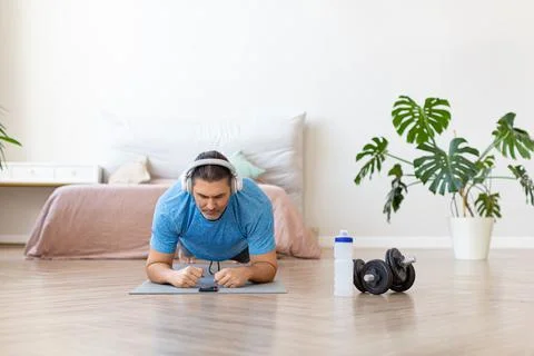 Close-up view of a middle-aged man doing the plank exercise. He follows the Stock Photos
