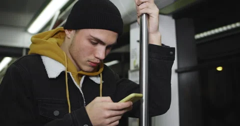 Close up view of millennial guy using his smartphone while going on public Stock Footage 136487480