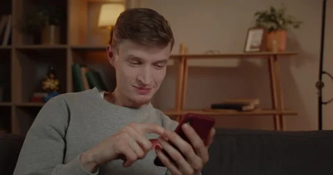 Close up view of millennial man scrolling smartphone screen and smiling in Stock-Footage 149323648
