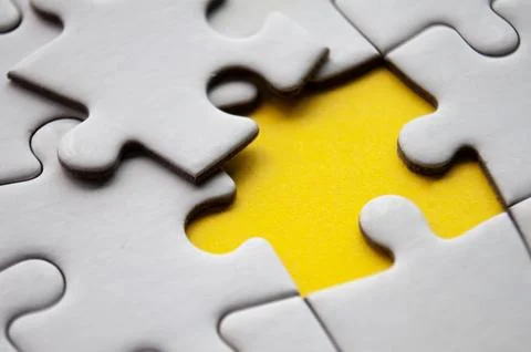 Close up view of missing jigsaw puzzle on yellow background. Copy space. Stock Photos