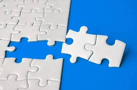 Close up view of missing white jigsaw puzzles, symbol of partnership and un.. Stock Photos