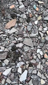 Close view of mixed broken bricks, stones, and debris on a rough ground surfa Stockfoto's