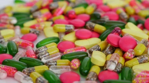 Close-Up View of Mixed Capsules and Tablets on White Background Stock Footage 303499652