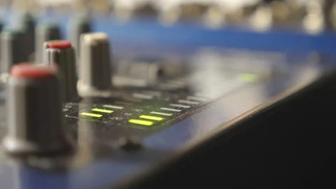Close up view of mixer soundboard with knobs and flashing green light indicators Video stock 92300398