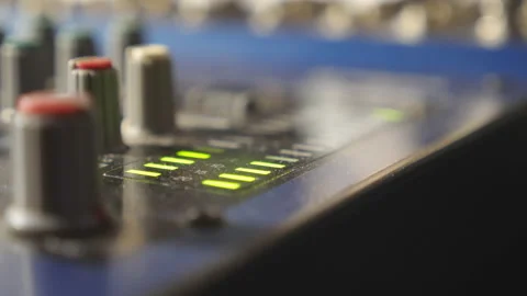 Close up view of mixer soundboard with knobs and flashing green light indicators 動画素材 231903636