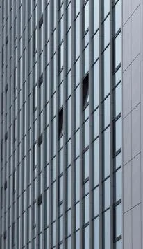 Close view of modern building facade with vertical window lines and geometric Foto stock