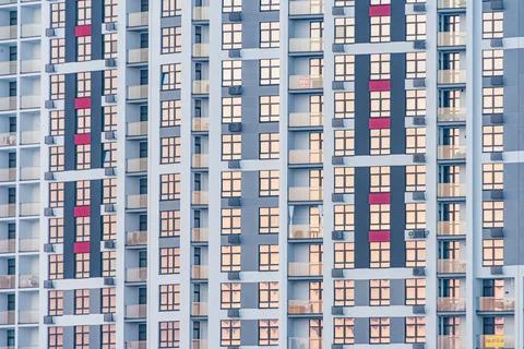 Close-up view of a modern building with red and gray window frames, situated  Stock Photos