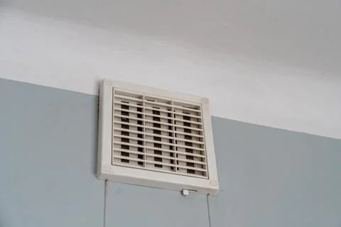 Close-up view of a modern ceiling vent cover installed in a white and light blue Fotos de archivo