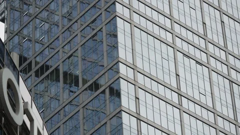 Close-up view of a modern glass skyscraper facade with reflective windows and Stock Footage 327531150