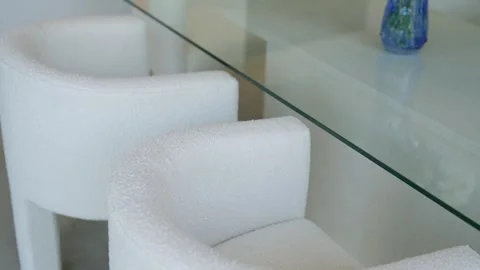 Close up view of modern interior setting focusing on white textured chair and Stock Footage 276026695
