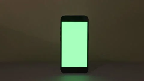 Close-up view of modern smartphone with green screen on green background, blank Video stock 165041842