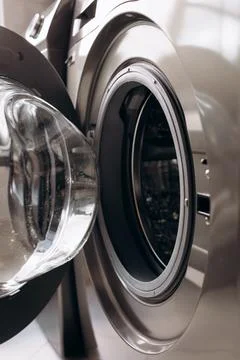 Close-up view of modern washing machine door with transparent glass and met.. Stock Photos