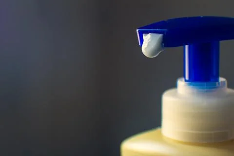 Close view of moisturizer dripping out of a bottle. Stock Photos