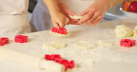 Close-up view of the mother hands kneading the dough while her son is using the Stock Footage 177000700