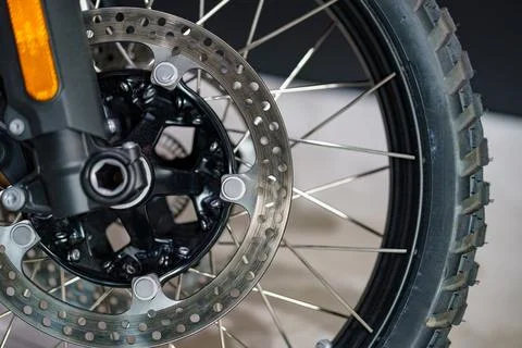 Close-up view of a motorcycle front wheel and brake disc showcasing intrica.. 库存照片