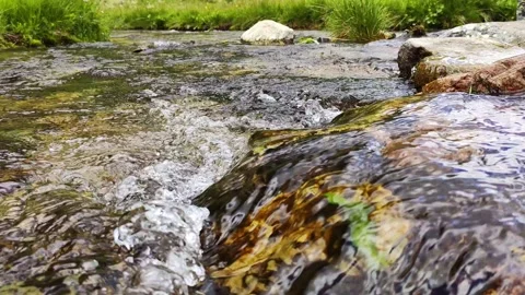 Close-up view mountain stream with stones and sky reflections Video stock 136189234