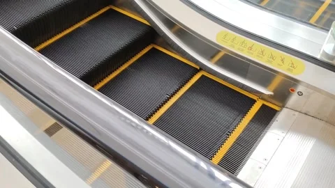 Close-Up View of a Moving Escalator With Metal Steps and Yellow Lines Stock Footage 302365857