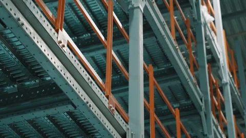 Close-up view of multi-tier industrial warehouse racking with orange safety Stock Footage 335861580