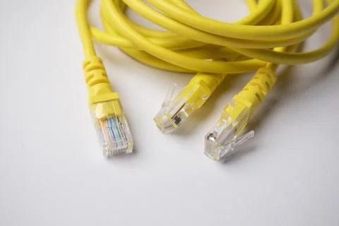 Close-up view of multiple RJ45 connectors attached to a coiled yellow Ether.. Stock Photos