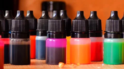 A close-up view of multiple small bottles filled with various vibrant paints Stock Footage 307693329