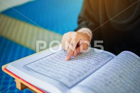 Close up view of muslim woman reading the holy Al Quran inside a mosque Stock Photos