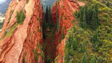 Close view of narrow chasm between Seven Bulls red rock pillars in Kyrgyzstan Stock Footage 344411464